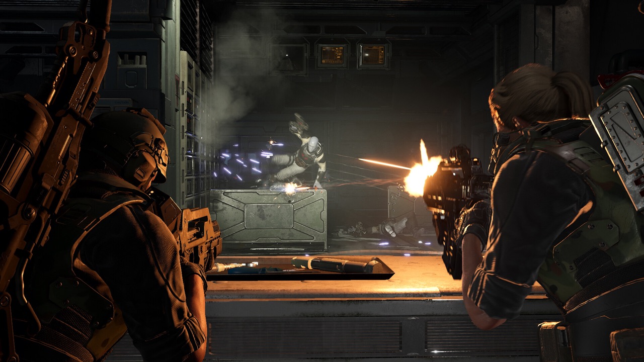 Four Colonial Marines fighting in a dark industrial mission in Aliens: Fireteam Elite 2
